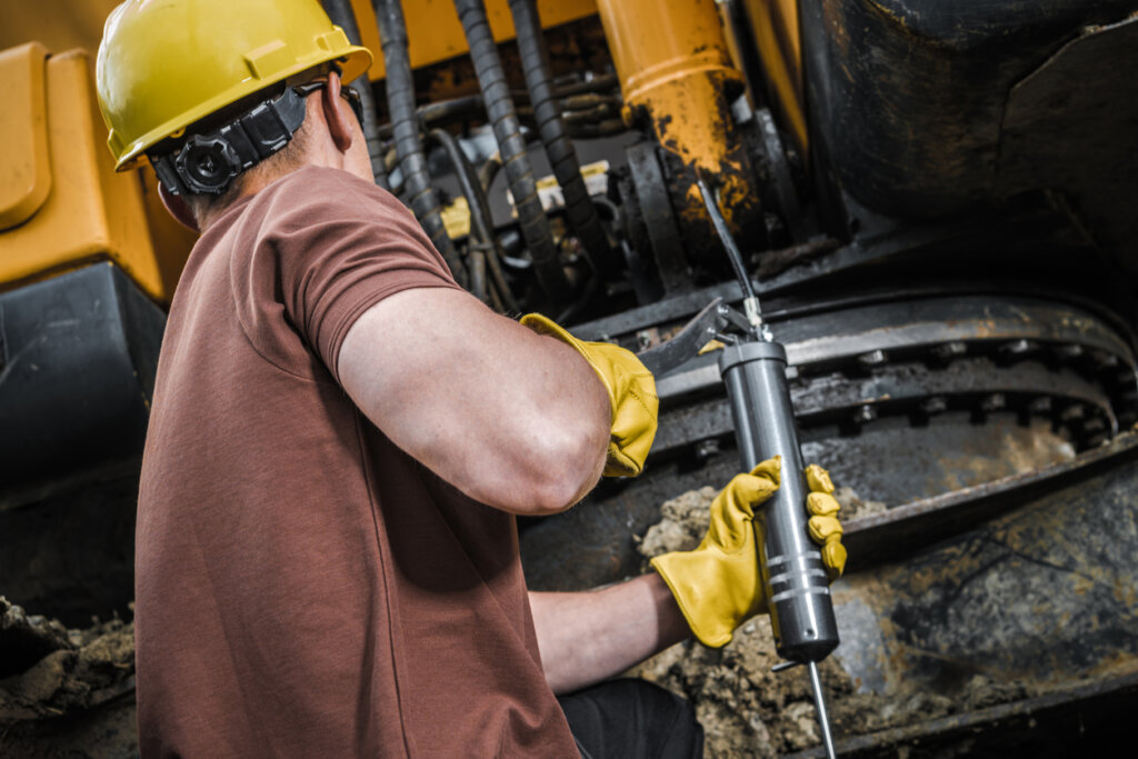 a man performing maintenance on an excavator